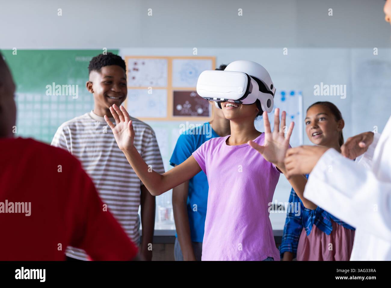 Utilizzando il visore VR, gli studenti in classe scolastica esplorano insieme la realtà virtuale Foto Stock