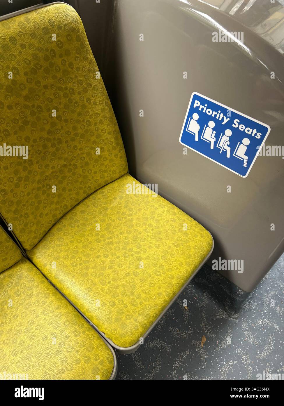 Vista verticale. Indicazione adesiva gialla prioritaria all'interno di un autobus pubblico. Lasciare il posto a incinta, adulto con bambino, anziano, disabilità. Singapore. Foto Stock