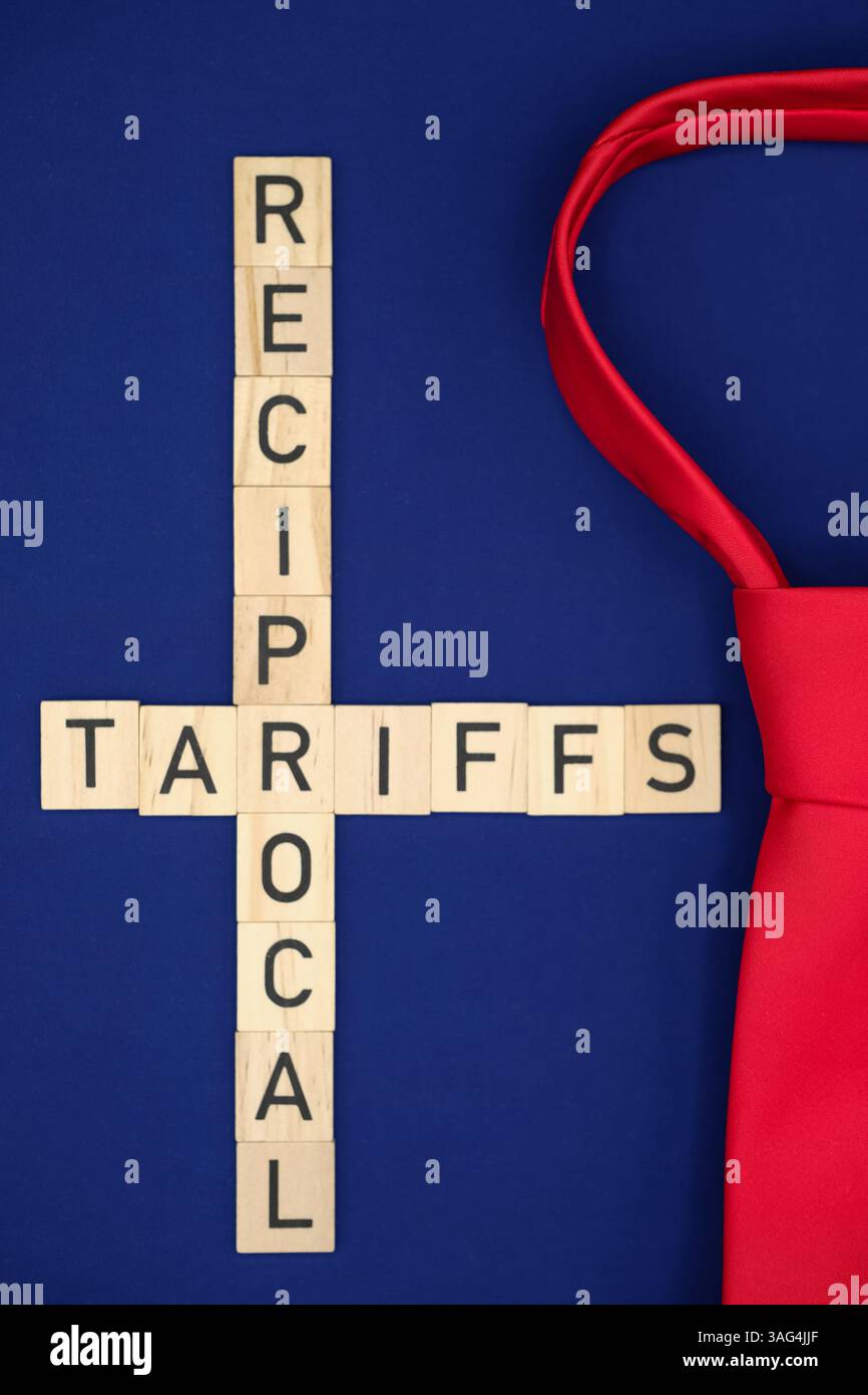 Le parole "tariffe reciproche”. Sfondo dei colori della bandiera americana. L'attenzione e' sulla cravatta rossa. Politica commerciale americana. Profondità ridotta. Foto Stock