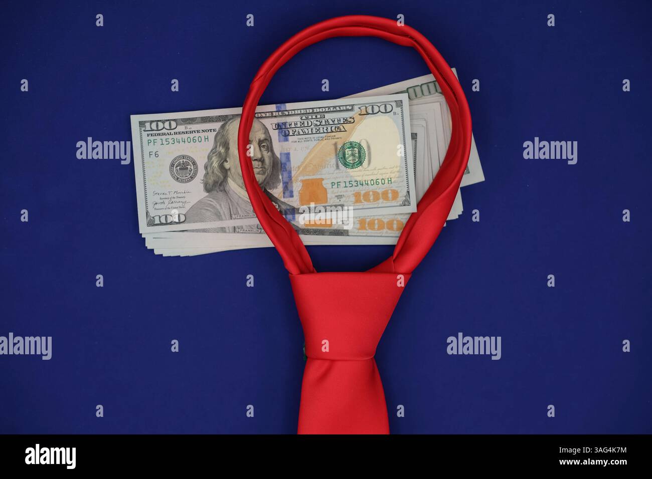 Immagine concettuale che rappresenta la pressione finanziaria e i vincoli economici. Banconote da un dollaro circondate da una cravatta rossa su sfondo blu, Foto Stock