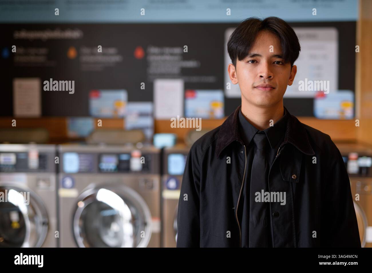 Ritratto di un uomo in un negozio di lavanderia che guarda la macchina fotografica Foto Stock