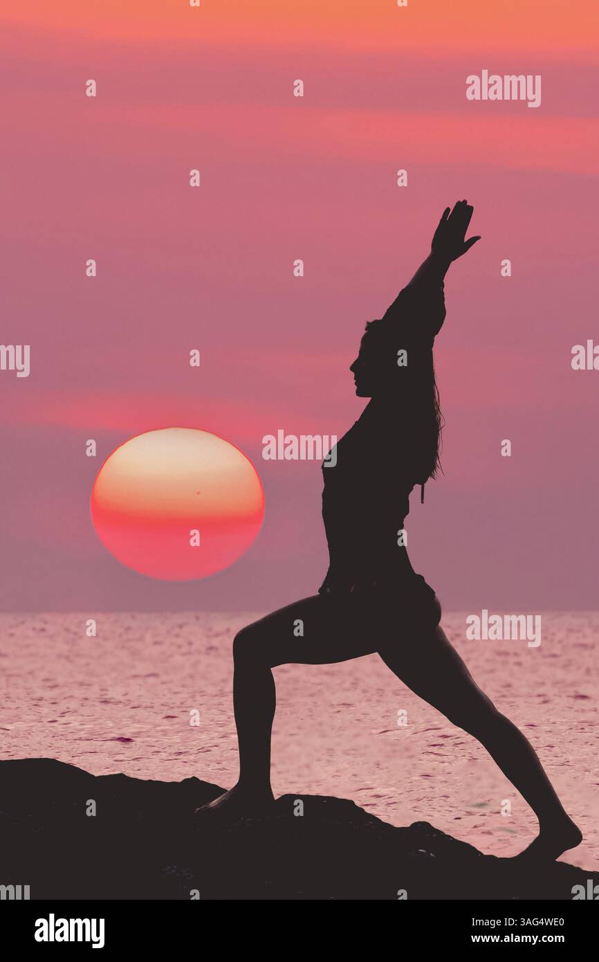 Una silhouette mozzafiato di uno Yogini che posa elegantemente al tramonto sullo sfondo mozzafiato del paesaggio oceanico, Una bella e serena silhouette Foto Stock