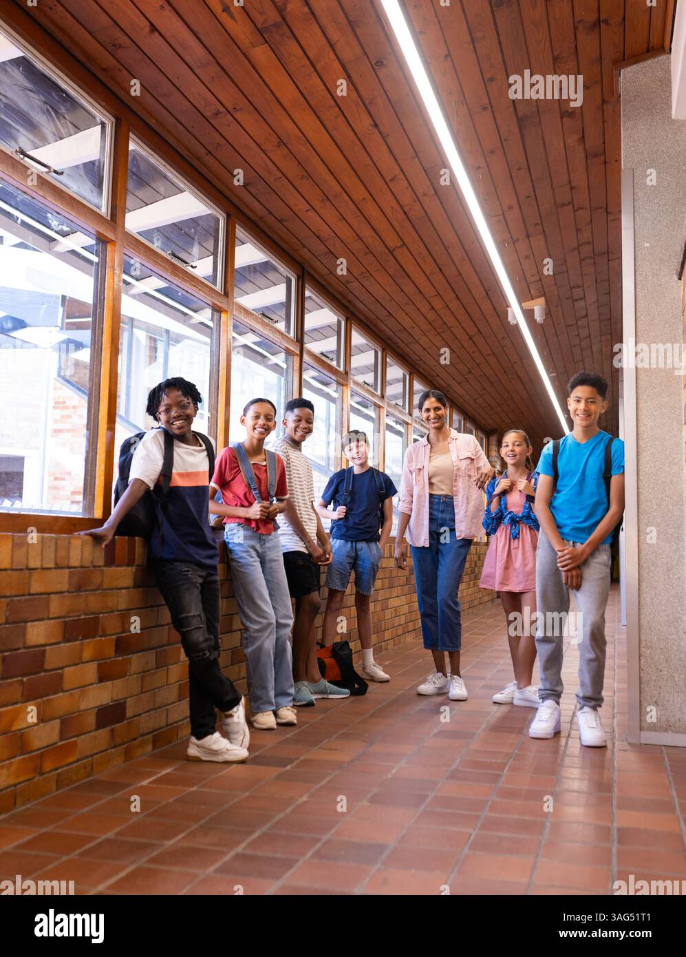 Gruppo di studenti in piedi nel corridoio della scuola, sorridendo e posando insieme Foto Stock Gruppo di studenti in piedi nel corridoio della scuola, sorridendo e posando insieme Foto Stock