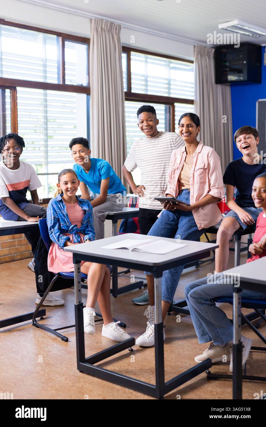 Gruppo di studenti e insegnante indiana che sorride in classe, godendo dell'ambiente scolastico Foto Stock