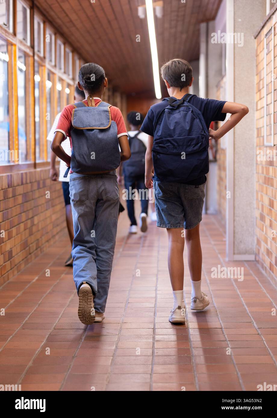 Camminando nel corridoio scolastico, studenti con zaini che vanno a lezione Foto Stock