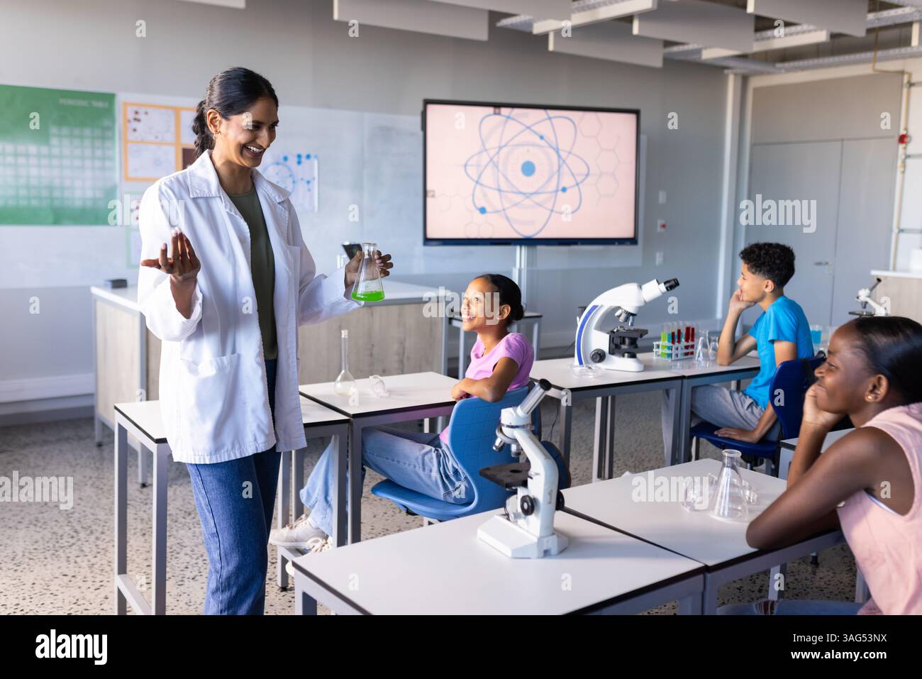 A scuola, insegnante indiana che conduce esperimenti scientifici con gli studenti in classe Foto Stock