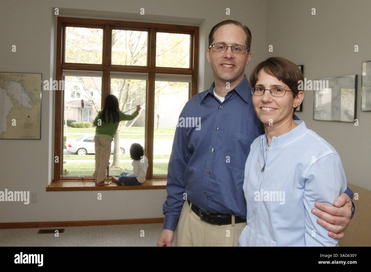 28 marzo 2012 - Saline, mi, USA - Steve Schwartz, 44, primo piano a sinistra, e Jill Schwartz, 44, di Saline, Michigan, nella foto del 29 marzo 2012, sono una coppia che ha adottato le loro due ragazze attraverso un'agenzia anni fa. La famiglia Schwartz, che ha ricevuto crediti di adozione sulle tasse sul reddito nel 2009 e nel 2010, pensa che il credito d'imposta aiuti i potenziali genitori ad aiutare con il costo di crescere un figlio. (Immagine di credito: © Jarrad Henderson/Detroit Free Press/MCT/ZUMAPRESS.com) Foto Stock