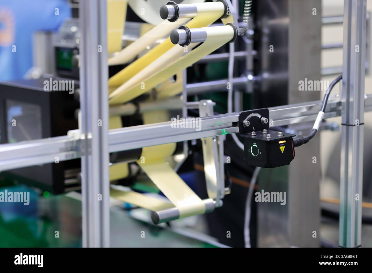 Linea di nastri trasportatori con etichettatrice automatica per adesivi e telecamera per visione artificiale industriale. Messa a fuoco selettiva. Foto Stock