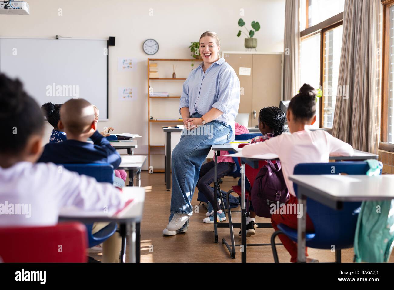 Coinvolgendo studenti diversi, insegnante femminile che promuove l'apprendimento interattivo in classe a scuola Foto Stock