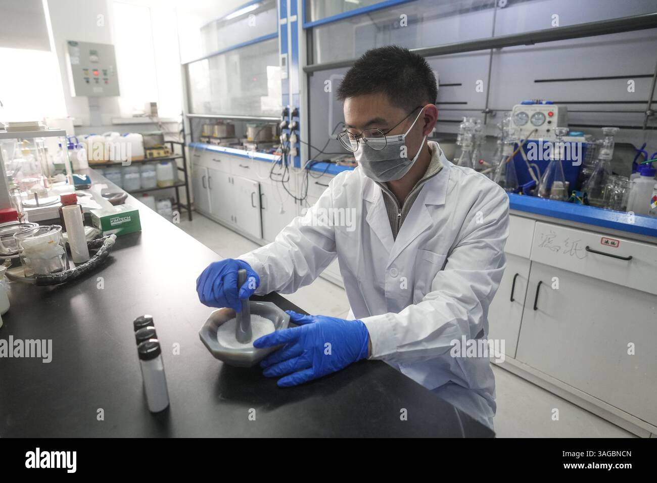 (250408) -- SHENYANG, 8 aprile 2025 (Xinhua) -- Un ricercatore macina il biossido di titanio dopo la riforma per spaccare direttamente l'acqua con la luce del sole, presso il laboratorio nazionale di scienza dei materiali di Shenyang dell'Istituto di ricerca sui metalli dell'Accademia cinese delle scienze a Shenyang, nella provincia di Liaoning della Cina nord-orientale, 7 aprile 2025. I ricercatori cinesi hanno recentemente raggiunto una svolta nella "spaccatura fotocatalitica dell'acqua per la produzione di idrogeno". Eseguendo la "rimodellatura strutturale" e la "sostituzione degli elementi" su un materiale semiconduttore, hanno notevolmente migliorato l'efficienza della conversione Foto Stock