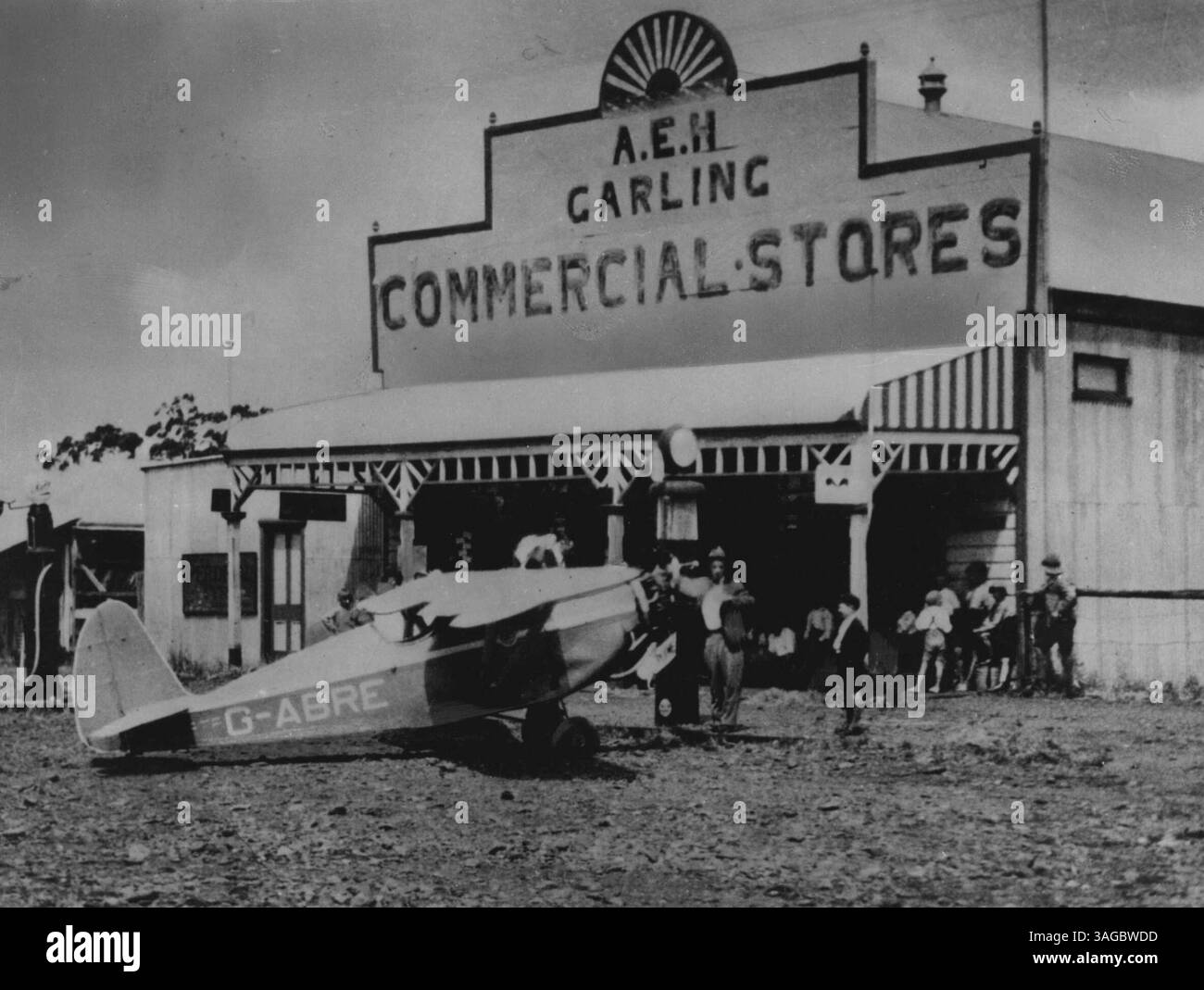 Nella fase finale di un volo record Inghilterra-Australia di 9 giorni, 1 ora e 43 minuti nel 1933, Arthur Butler ora (1953) amministratore delegato della terza compagnia aerea nazionale australiana Butler Air Transport Pty. Ltd. -- ha rifornito il suo compter Swift monoplano per le strade della cittadina di Tooraweena nel New South Wales. La figlia del proprietario del negozio in seguito divenne sua moglie. 30 novembre 1955. (Foto di John Tanner, fotografia ufficiale australiana) Foto Stock