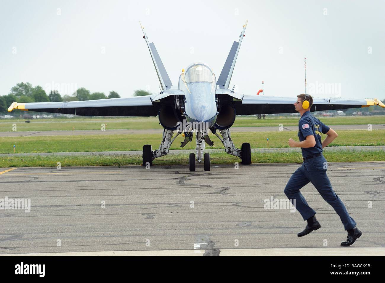23 maggio 2012 - Farmingdale, New York, U. S - 23 maggio 2012-FAMINGDALE, NEW YORK- Un membro dell'equipaggio di terra scappa via mentre lo squadrone dimostrativo Blue Angels della Marina degli Stati Uniti accende i loro motori prima di partire dall'Aeroporto della Repubblica di Farmingdale per un volo sul fiume Hudson mercoledì mattina 23 maggio 2012. Il cavalcavia simboleggia l'inizio della Fleet Week di New York e commemora il 200° anniversario della guerra del 1812. I Blue Angels parteciperanno al Jones Beach New York Airshow di questo fine settimana. NEW YORK DAILY QUOTIDIANI OUT (immagine di credito: © Kevin Coughlin/ZUMAPRESS.com) Foto Stock