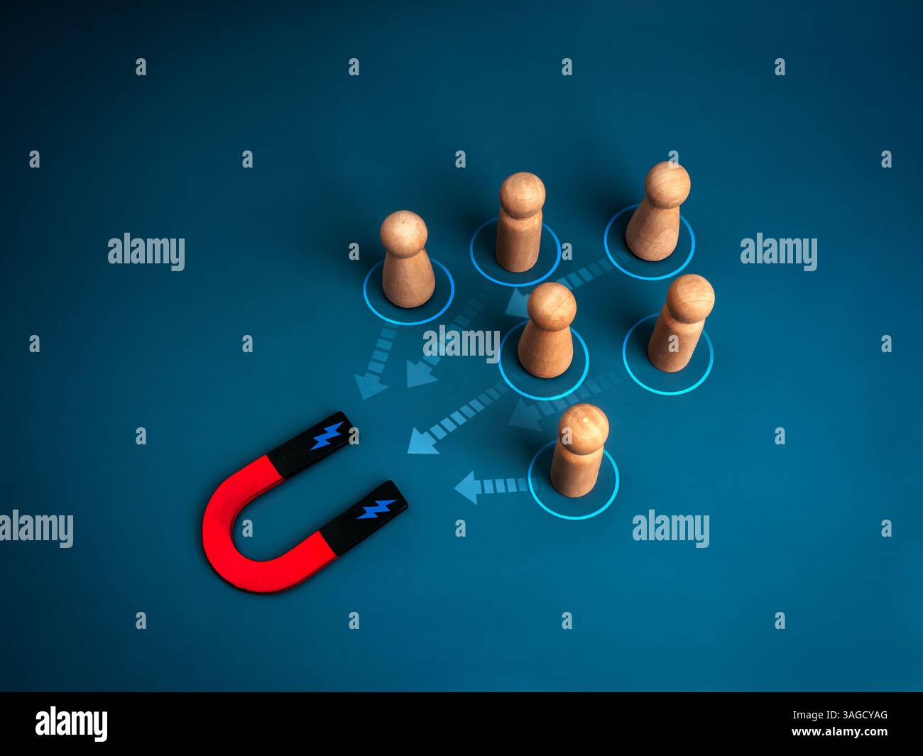 Marketing digitale, target di pubblico, attrarre lead e concept dei clienti. Simboli umani in legno attratti dal magnete a ferro di cavallo con frecce sul dorso blu Foto Stock