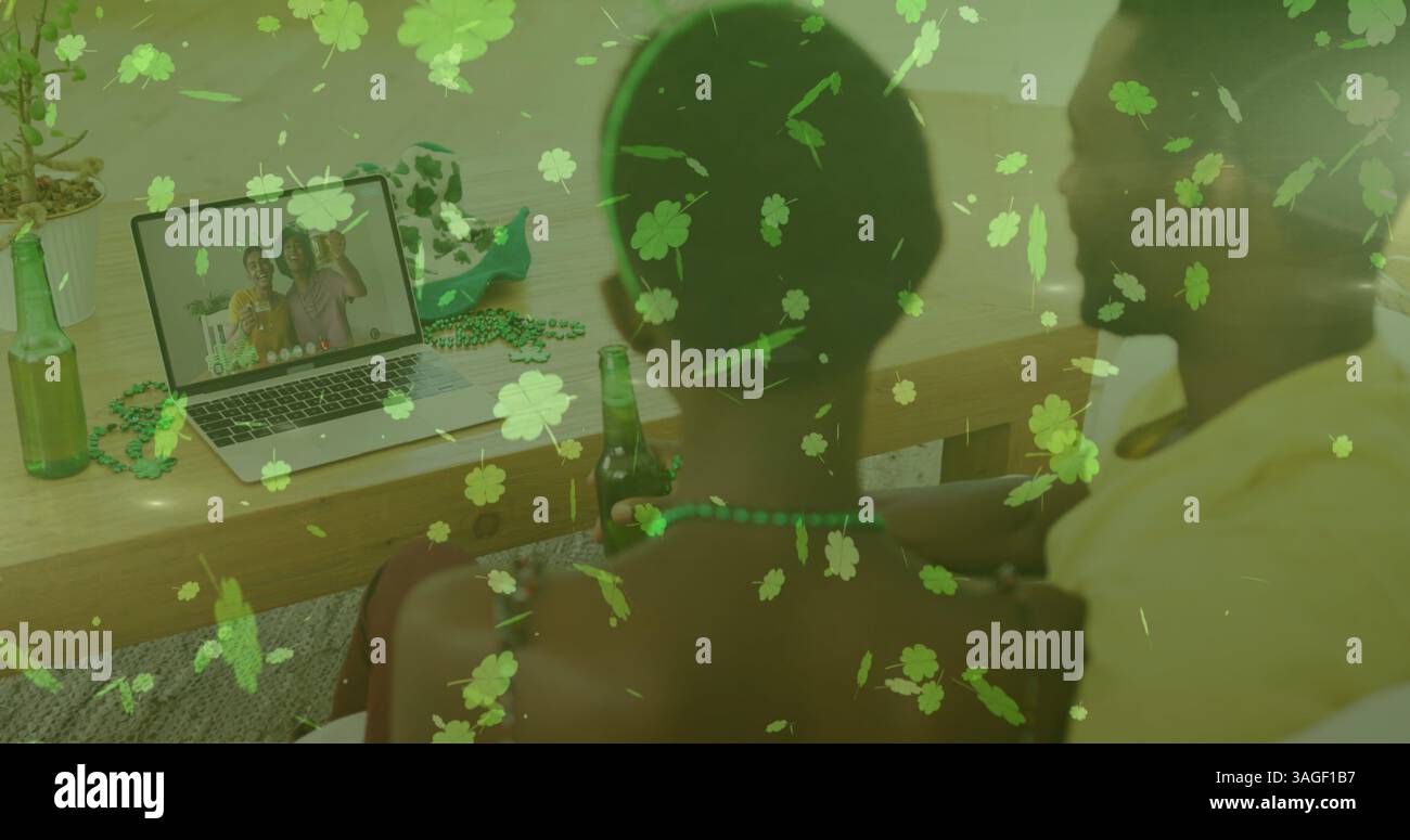 Clover lascia cadere contro la coppia che tiene in mano le birre e riceve un'immagine sul laptop a casa Foto Stock Clover lascia cadere contro la coppia che tiene in mano le birre e riceve un'immagine sul laptop a casa Foto Stock