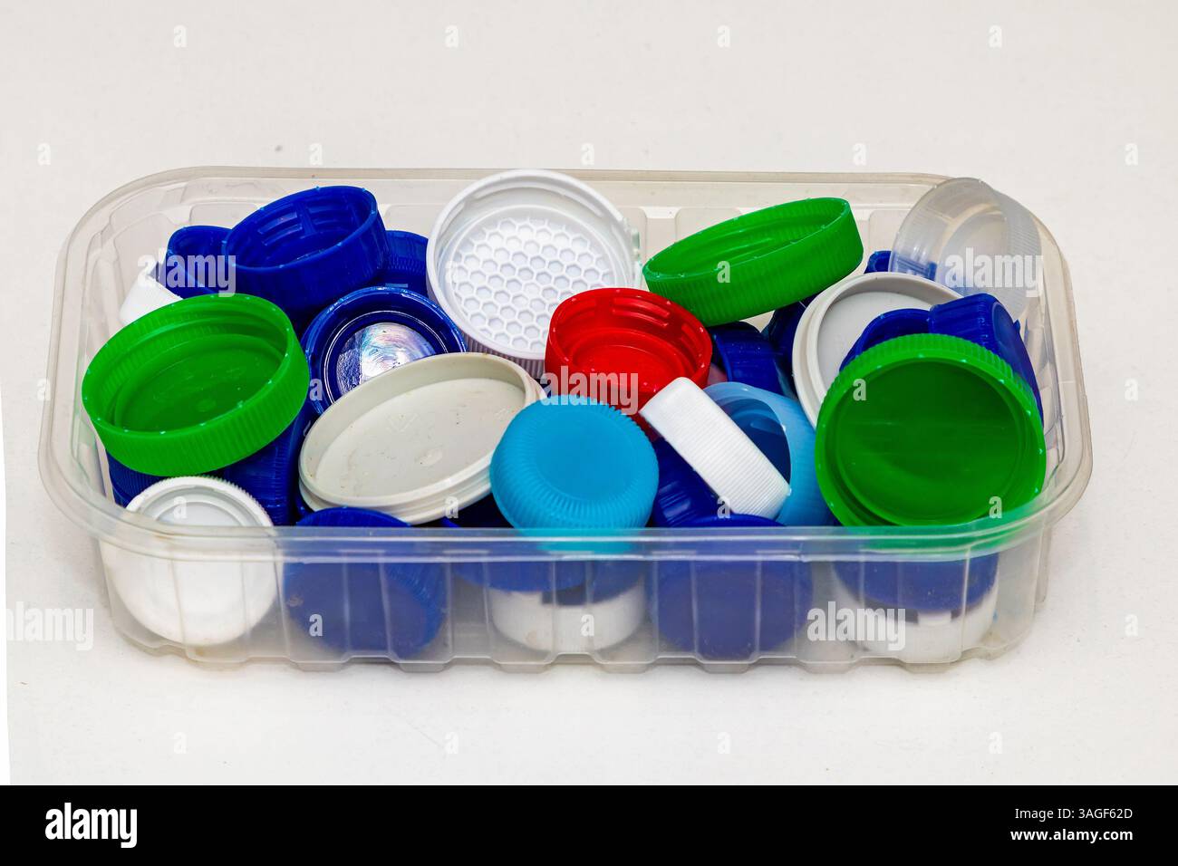 Pile di tappi colorati in plastica pronti per il riciclaggio Foto Stock