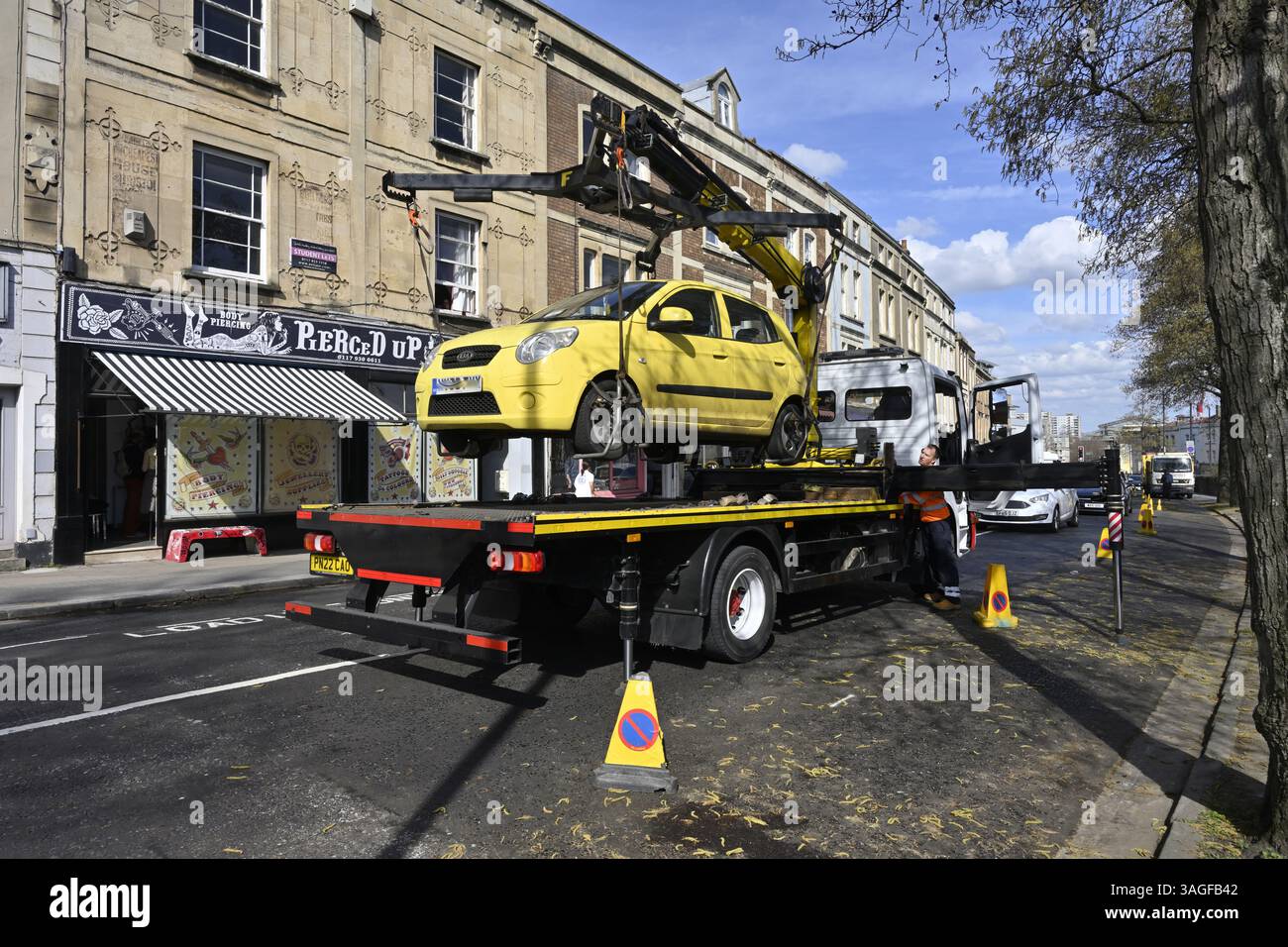 La vettura gialla viene sollevata sul retro del rimorchio per spostarla in un'altra posizione Foto Stock
