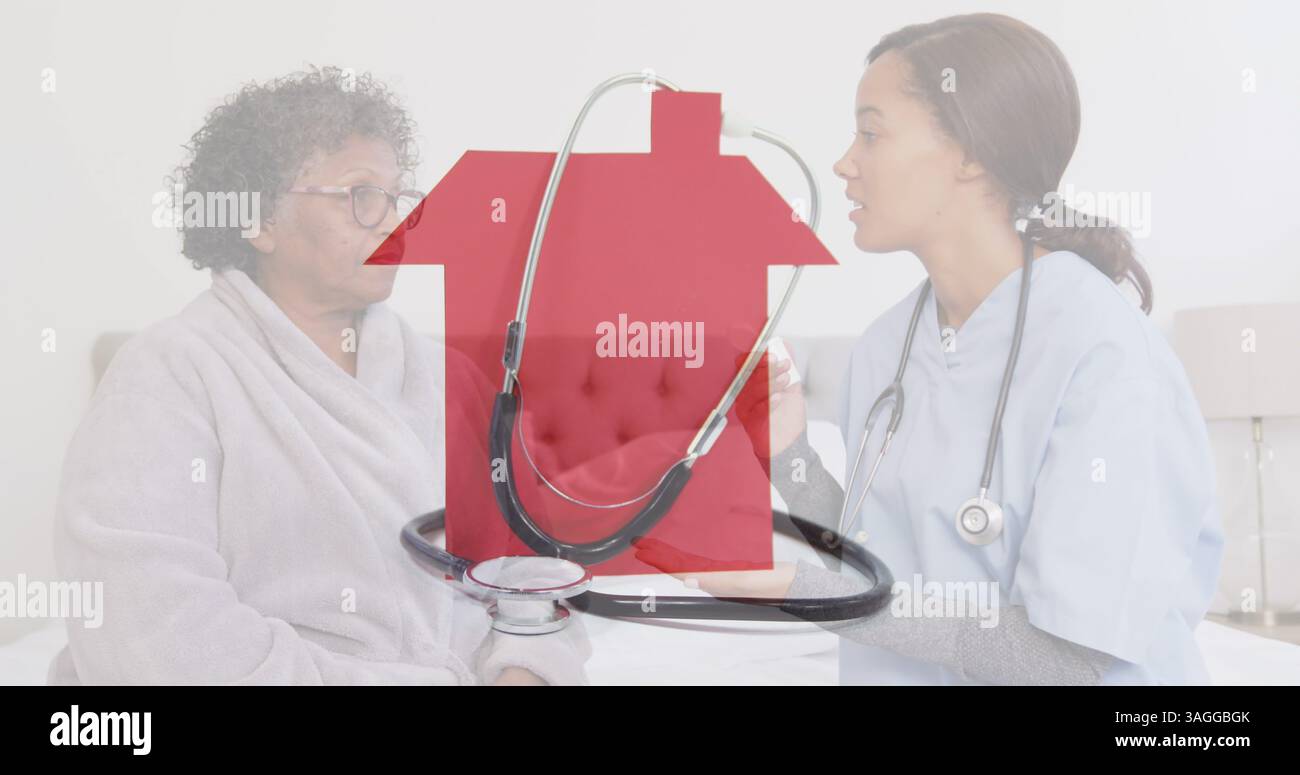 Immagine dello stetoscopio sulla casa rossa sopra un medico donna con una donna anziana che parla Foto Stock