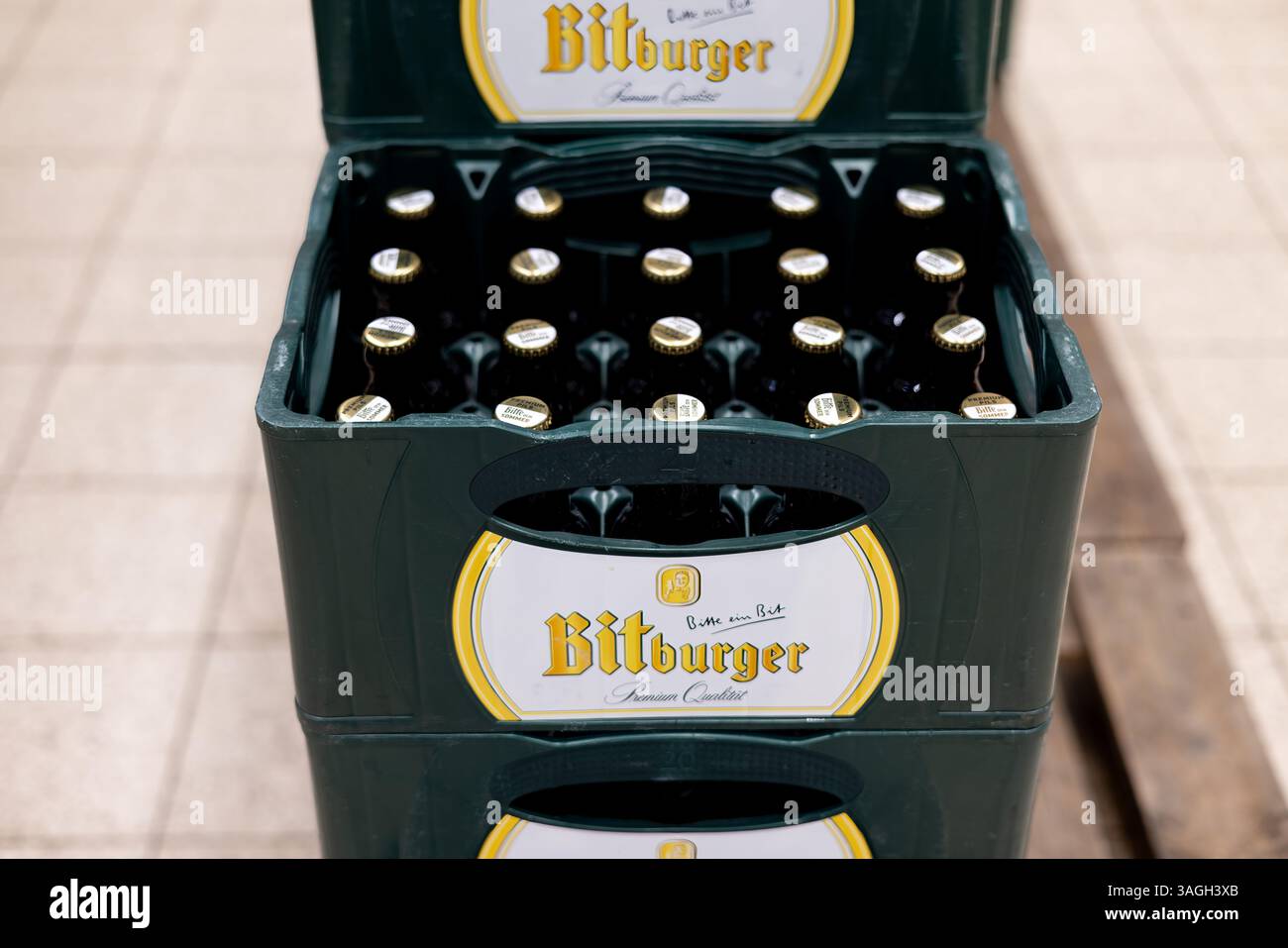 Una presentazione strutturata delle bottiglie di birra Bitburger collocate ordinatamente all'interno di una cassa verde, che mostra la loro qualità premium. - FRANCOFORTE, GERMANIA - MARZO Foto Stock
