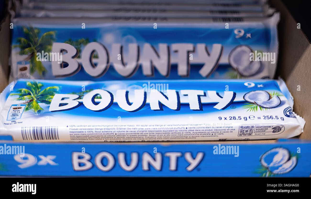 Una gamma visivamente allettante di barrette di cioccolato Bounty, che mostrano la giocosa confezione blu che promette una deliziosa esperienza di cocco e cioccolato. Foto Stock
