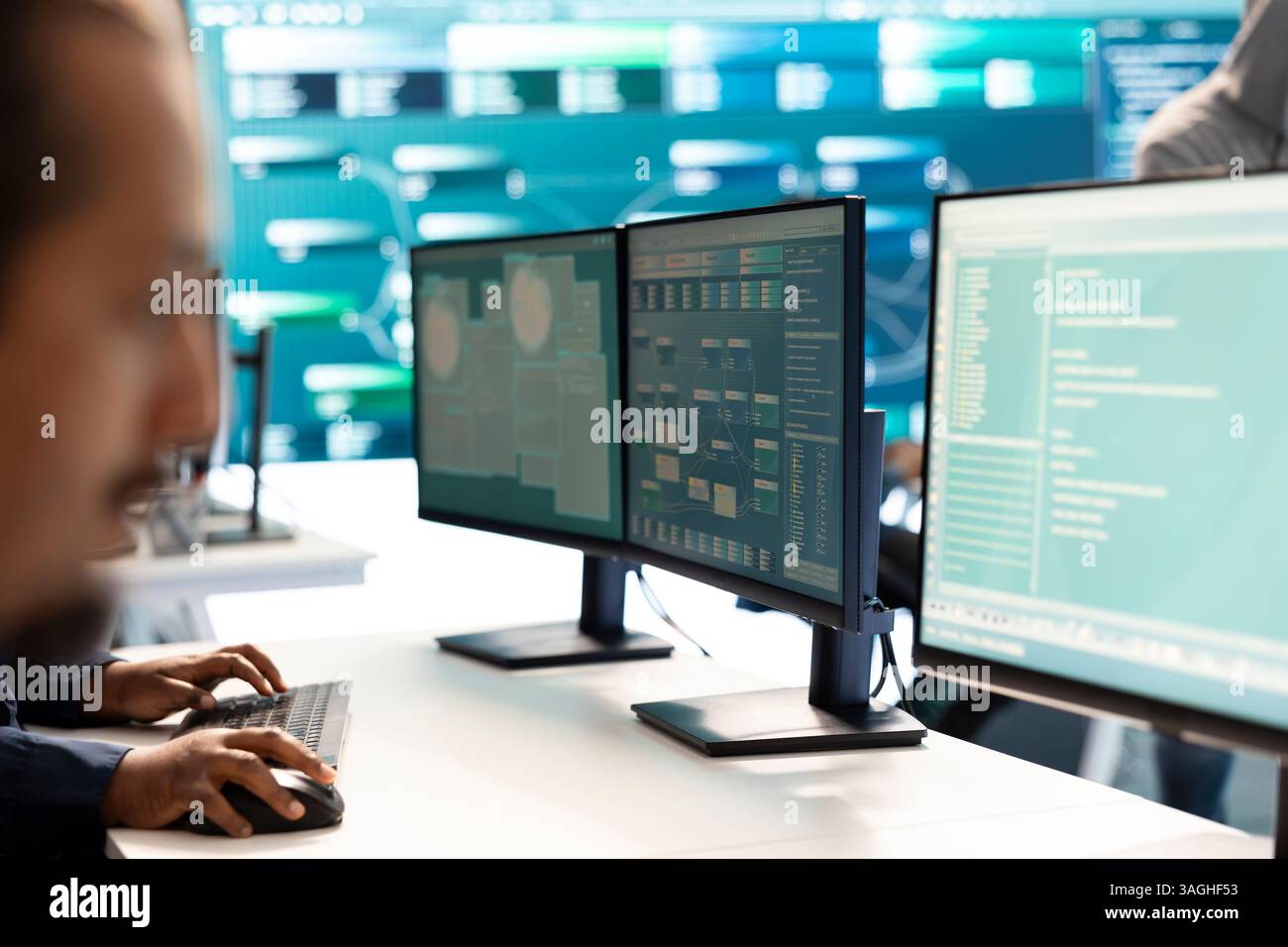 Hacker governativi che indagano sugli incidenti informatici e monitorano le minacce alla sicurezza su un grande schermo. Una donna specialista utilizza tecniche di phishing per rubare informazioni importanti per la guerra informatica. Foto Stock