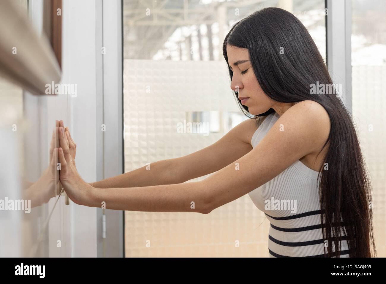 Con gli occhi chiusi e il corpo stabile, costruisce forza e controllo attraverso ogni spinta contro il muro. Foto Stock