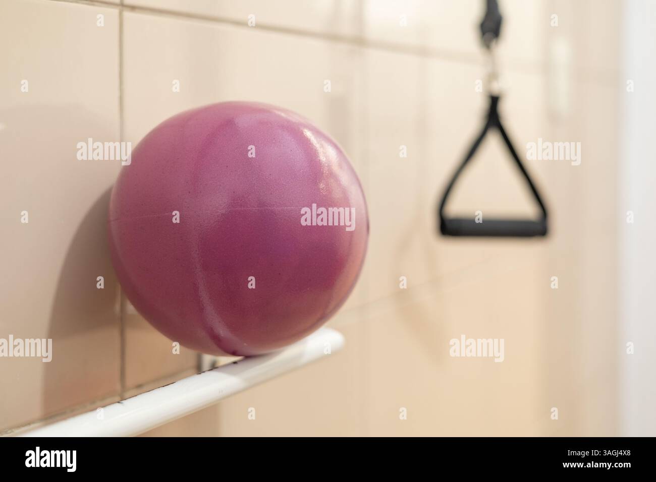Una palla viola si appoggia tranquillamente sulla sponda, in attesa che il paziente successivo ricominci il suo percorso verso il movimento. Foto Stock