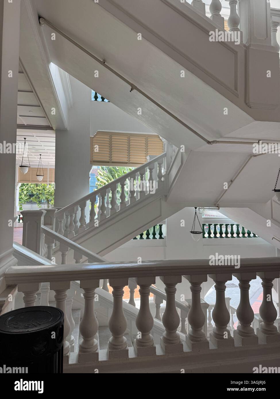 Elegante scalinata coloniale al Raffles Hotel, Singapore. Architettura storica iconica e design degli interni senza tempo. - Immagine stock catturata con smartphone