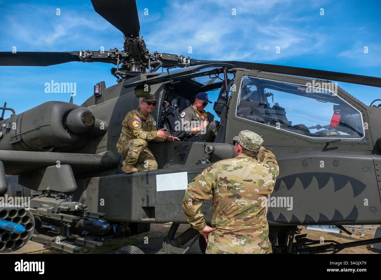 Il Chief Warrant Officer 2 Brad Jaillet (L) mostra l'interno di Apache AH-64 a un pilota australiano durante un evento stampa presso l'Avalon Airfield. Foto Stock