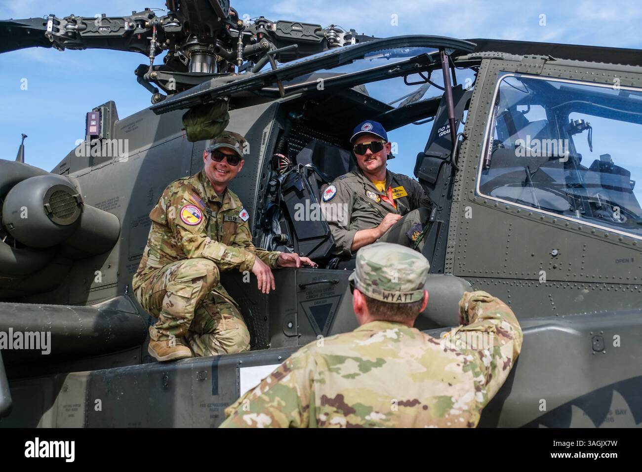 Il Chief Warrant Officer 2 Brad Jaillet (L) mostra l'interno di Apache AH-64 a un pilota australiano durante un evento stampa presso l'Avalon Airfield. Foto Stock