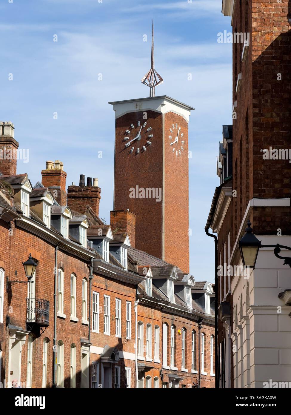 Shrewsbury, Regno Unito - 31 marzo 2025; Shrewsbury Market Hall orologio su torre di mattoni che si innalza sopra vecchie case Foto Stock