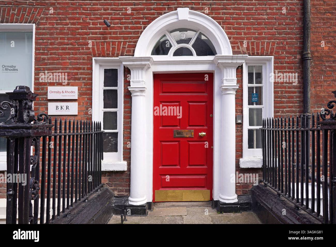 Porta d'ingresso rossa luminosa dell'ufficio contabile di Dublino nella residenza cittadina georgiana Foto Stock