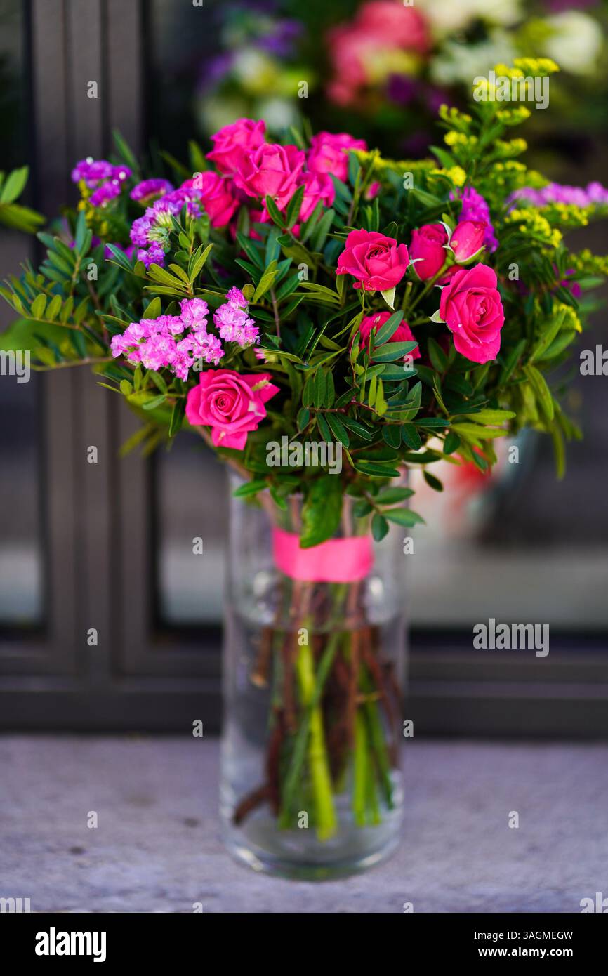 Un bellissimo e vibrante bouquet di fiori misti in un vaso, perfetto per l'arredamento della casa, le celebrazioni e i progetti a tema floreale Foto Stock