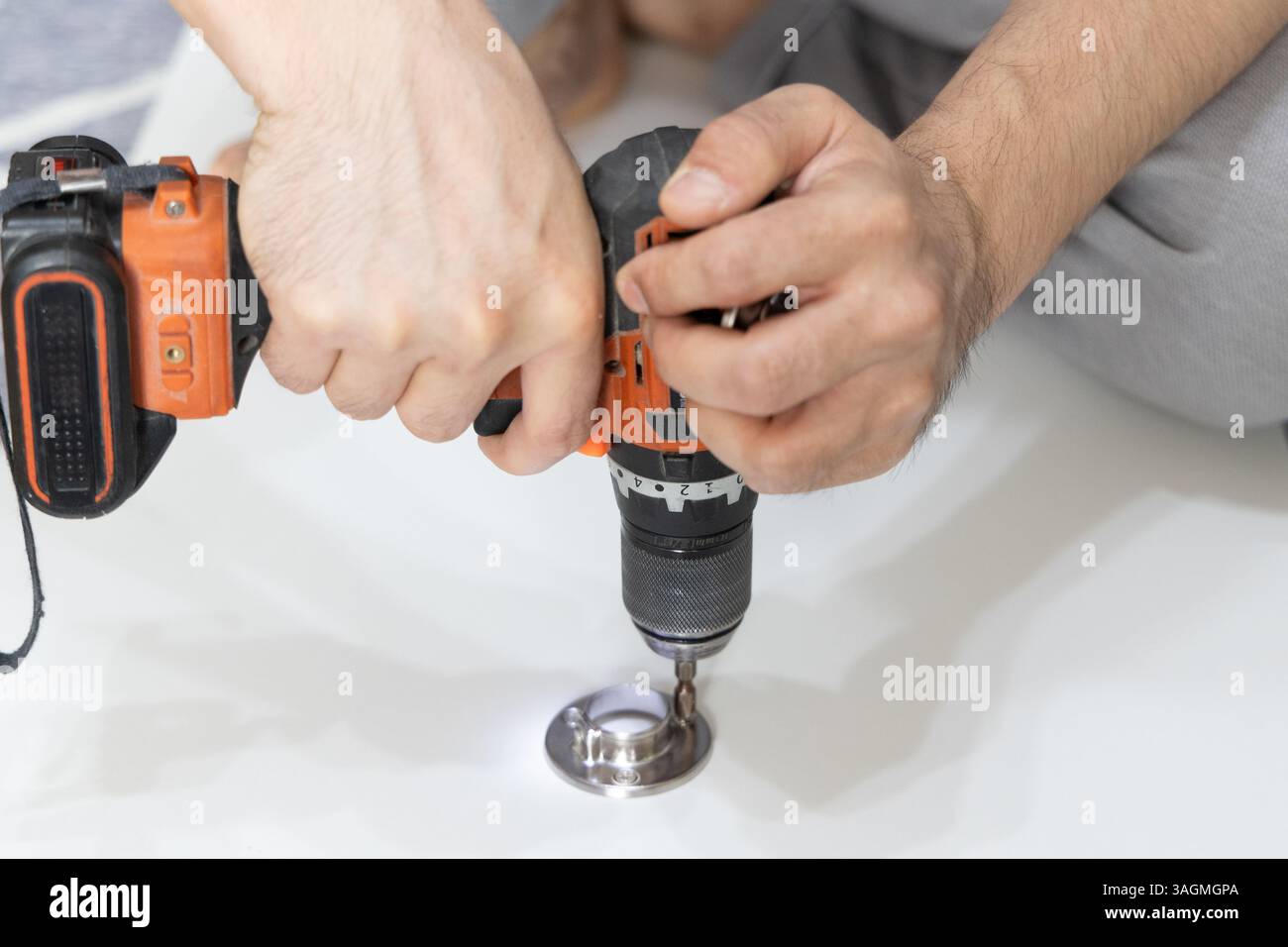 Primo piano delle mani maschili utilizzando un cacciavite per serrare la vite. Foto Stock