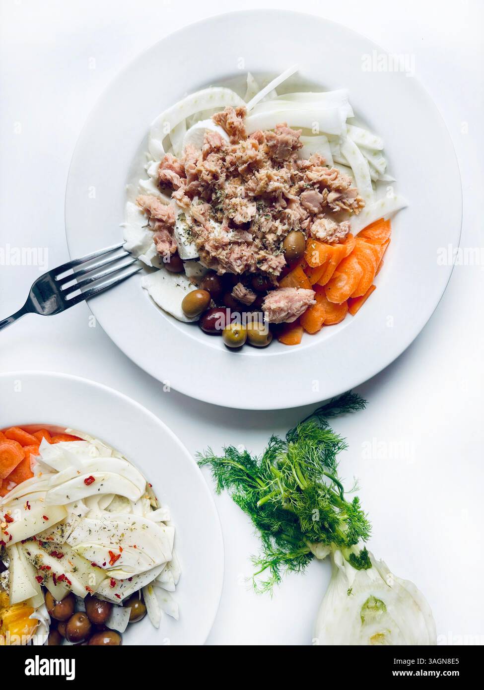 Insalata di finocchio con tonno e verdure fresche, formaggio, olive isolate su fondo bianco. Cibo sano. Direttamente sopra. Foto Stock
