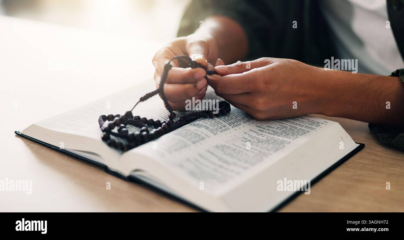 Bibbia, mani e persona che leggono un libro con rosario nella religione spirituale per la pace, la guida e l'apprendimento. Perline, casa o culto con lode Foto Stock
