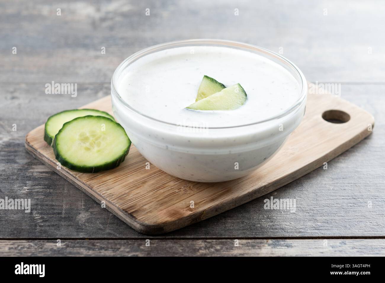 Salsa Tzatziki greca nel recipiente su un tavolo di legno Foto Stock