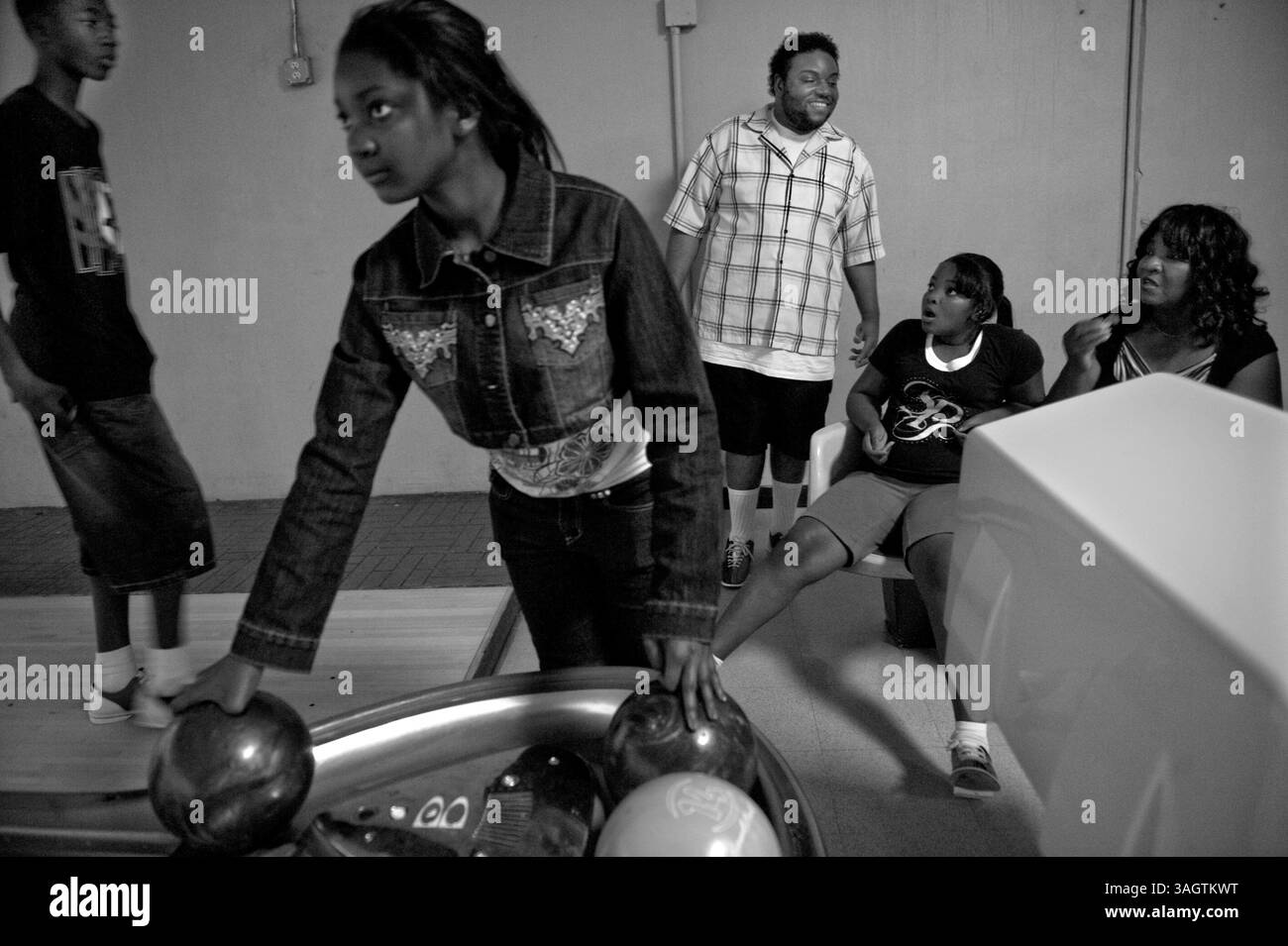 Marlon Barton, 26 anni, in background rimane fissato nella stessa posizione tutta la notte quando non sta giocando a bowling o mangiando all'AMF Bowling di Sacramento. Qui è circondato da sua madre Pearlie Barton, 58 anni, destra, e suo nipote Lejae Thompson, 13 anni, sinistra e nipoti Mariah Thompson, 11 anni, centro e Shanice Thompson, 9 anni. Foto scattate sabato 20 giugno 2009. (Immagine di credito: © Sacramento Bee/ZUMA Press) Foto Stock Marlon Barton, 26 anni, in background rimane fissato nella stessa posizione tutta la notte quando non sta giocando a bowling o mangiando all'AMF Bowling di Sacramento. Qui è circondato da sua madre Pearlie Barton, 58 anni, destra, e suo nipote Lejae Thompson, 13 anni, sinistra e nipoti Mariah Thompson, 11 anni, centro e Shanice Thompson, 9 anni. Foto scattate sabato 20 giugno 2009. (Immagine di credito: © Sacramento Bee/ZUMA Press) Foto Stock