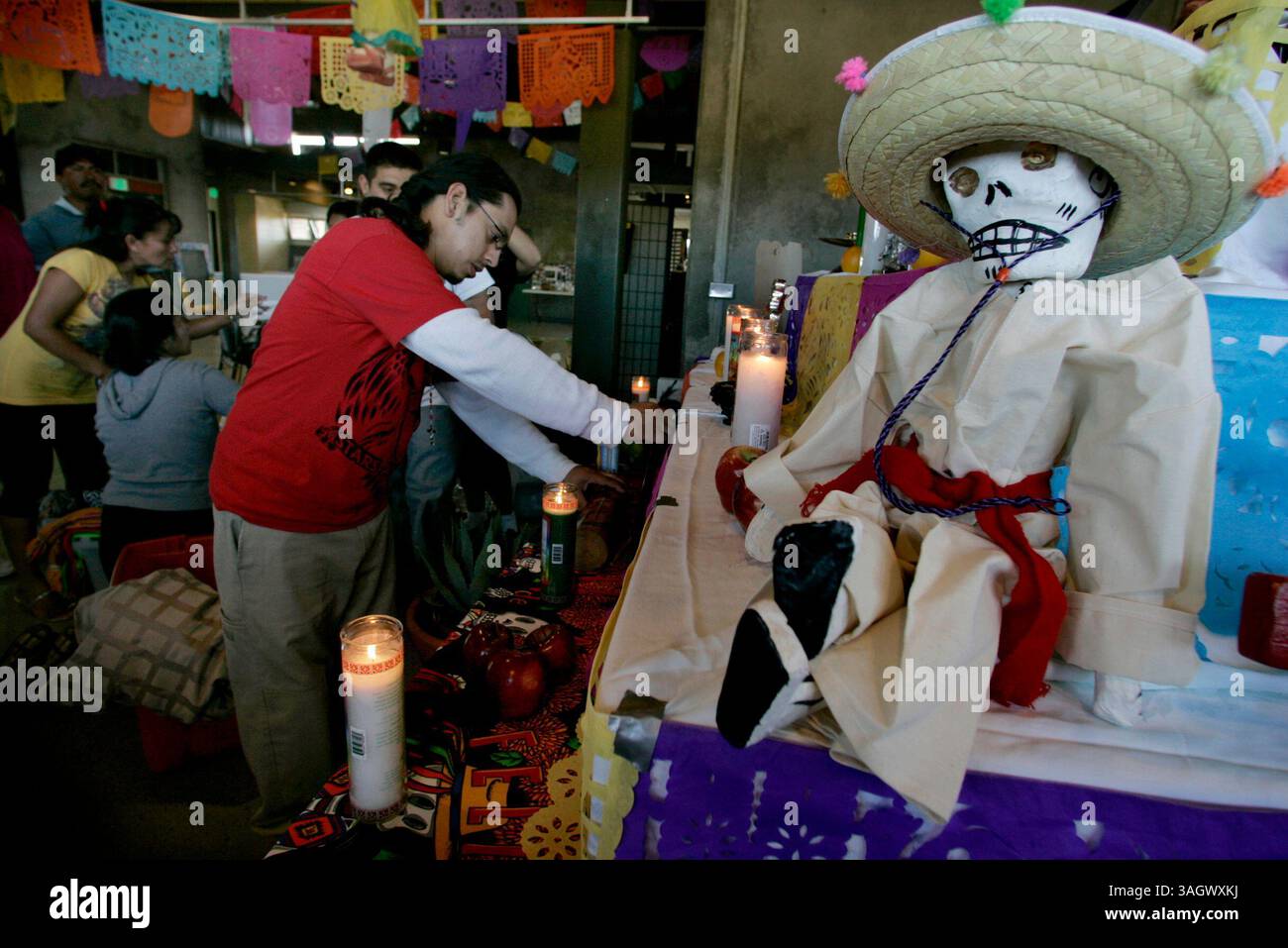 26 ottobre 2009, San Diego, California, USA DAVID SIERRA, a sinistra, e altri membri del gruppo di danza Danza Azteca calpulli Mexicatl (cq), benedicono gli oggetti con l'incenso e li collocano sull'altare che stanno creando al Sherman Heights Community Center Lunedi come parte della celebrazione di una settimana che porta a dia de los Muertos. Le persone della comunità allestiranno i loro altari all'interno del centro tutta la settimana, e i bambini delle scuole faranno escursioni per vederli. Nel fine settimana, un sacerdote benedirà gli altari, ci sarà cibo, i ballerini si esibiranno. La tradizione in gran parte messicana Foto Stock