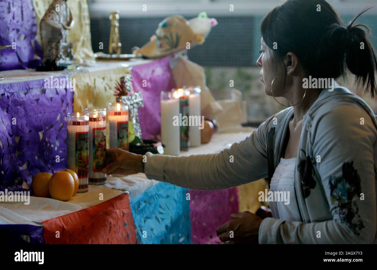 26 ottobre 2009, San Diego, California, Stati Uniti membri del gruppo di danza azteco Danza Azteca calpulli Mexicatl (cq), benedice gli oggetti con l'incenso e li colloca sull'altare che stanno creando presso lo Sherman Heights Community Center Lunedi come parte della celebrazione di una settimana che porta a dia de los Muertos. Le persone della comunità allestiranno i loro altari all'interno del centro tutta la settimana, e i bambini delle scuole faranno escursioni per vederli. Nel fine settimana, un sacerdote benedirà gli altari, ci sarà cibo, i ballerini si esibiranno. La tradizione in gran parte messicana di decorare gli altari è m Foto Stock