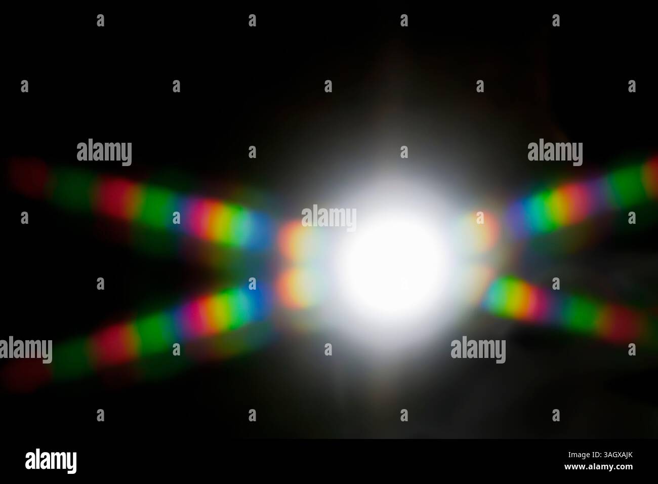 Diffrazione. Schema astratto formato da luce diffusa. Una raffica di luce bianca dispersa nello spettro di colori visibile. La luce bianca può essere re Foto Stock