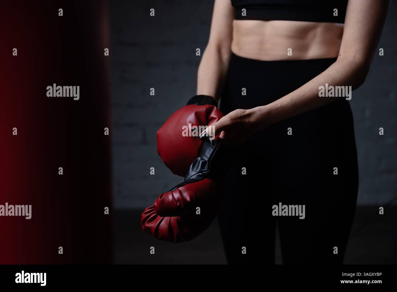 donna che indossa guanti da boxe prima di allenarsi in palestra Foto Stock