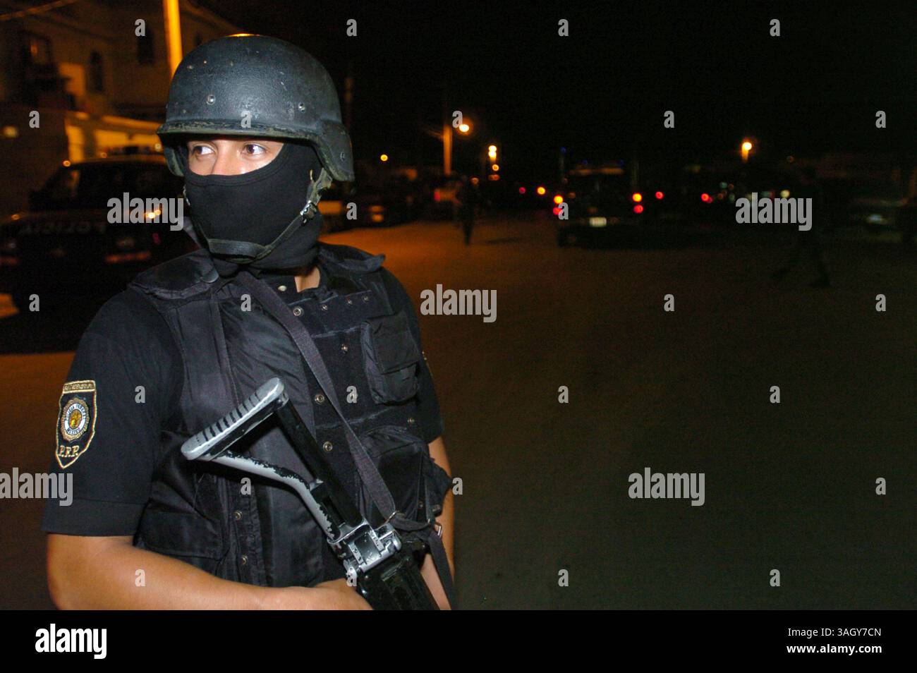 25 giugno 2005 - Nuevo Laredo, Tamaulipas, Messico - Un ufficiale di polizia federale ha fatto la guardia in un quartiere della classe operaia a Nuevo Laredo, Messico, durante un raid in case sicure che ha portato al salvataggio di 43 vittime dei rapimenti. Le autorita' hanno detto che le vittime potrebbero avere legami con uno dei potenti cartelli della droga del Messico. (Immagine di credito: © Luis J. Jimenez/ZUMA Press) Foto Stock