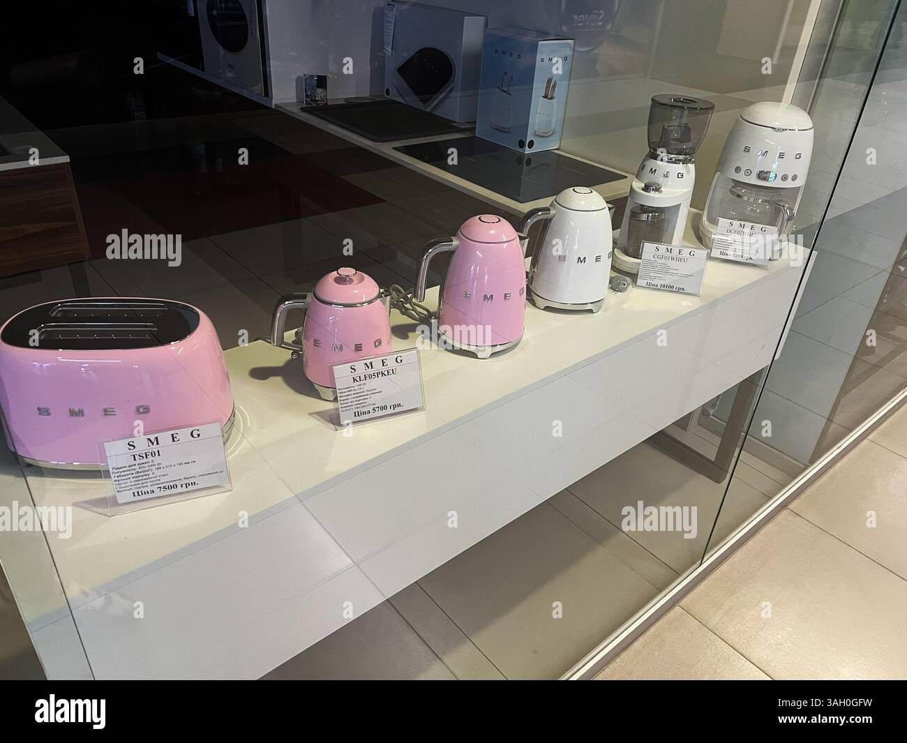 Kiev, Ucraina - 8 aprile 2025: Vetrina di elettrodomestici SMEG rosa e bianco, tra cui tostapane, bollitori e macinacaffè Foto Stock