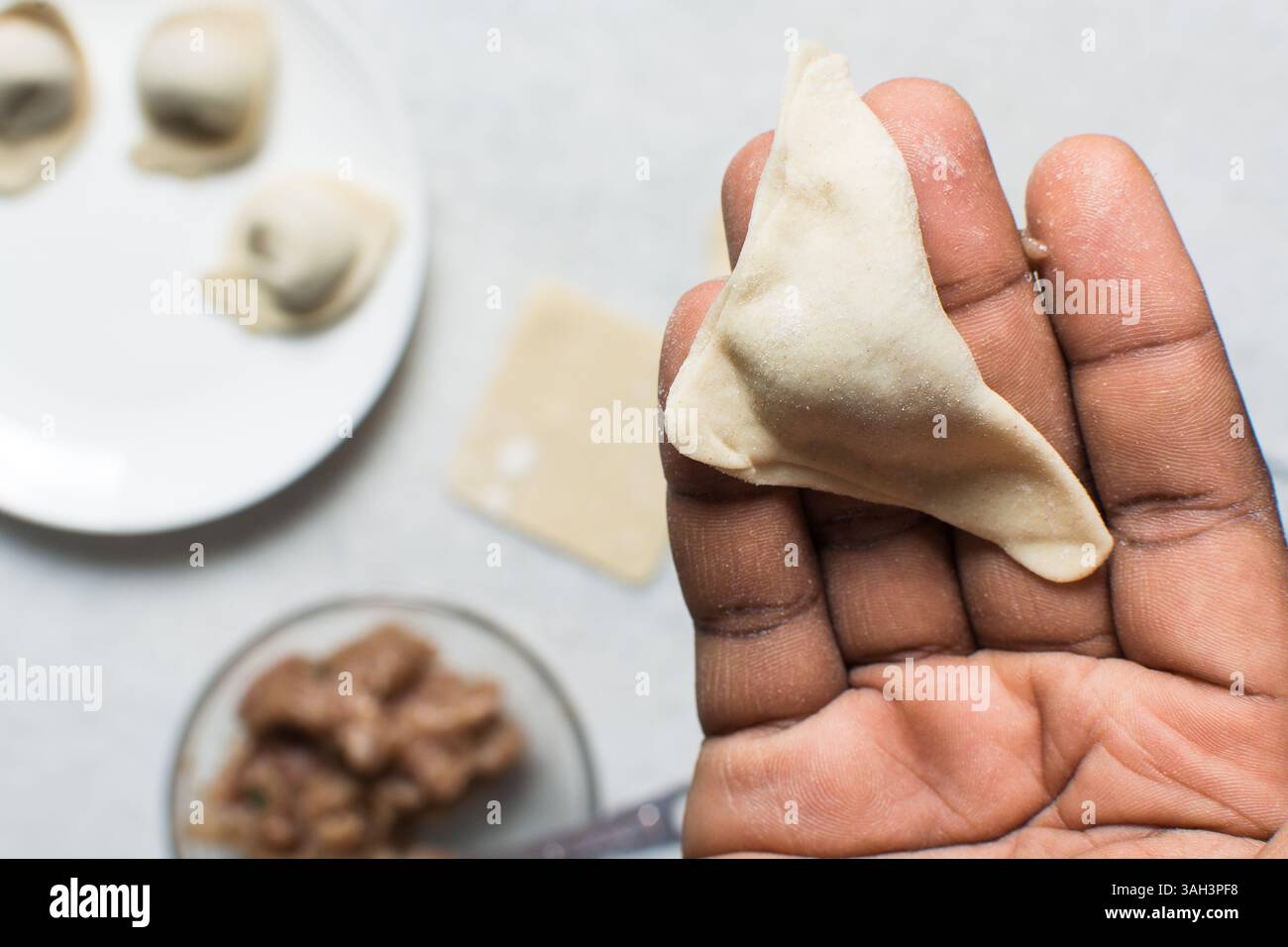 Vista dall'alto del gnocco avvolto, vista dall'alto del wonton riempito, processo di produzione dei wonton fatti in casa Foto Stock