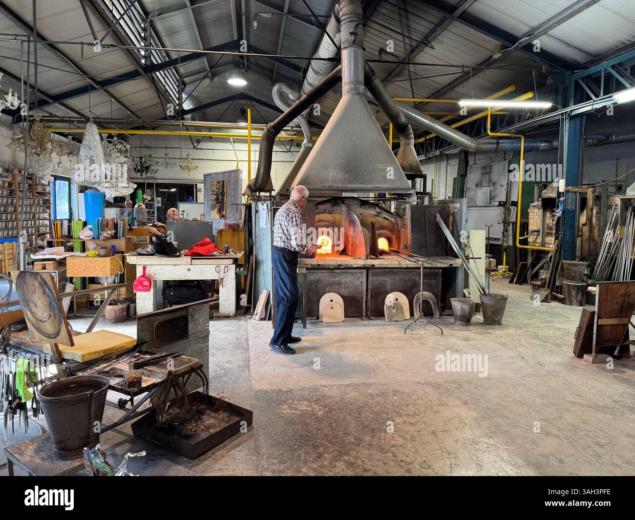All'interno di una fabbrica di vetro di Murano. Un maestro sta mostrando ai visitatori come vengono realizzati i pezzi. Foto Stock