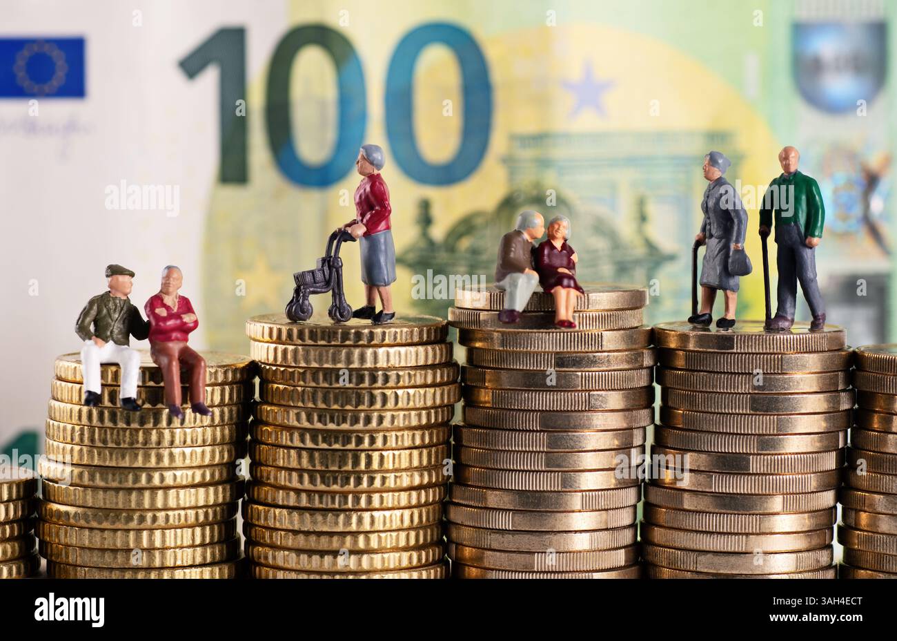 Foto simbolo con cifre del pensionato su pile di monete con una banconota da cento euro sullo sfondo Foto Stock