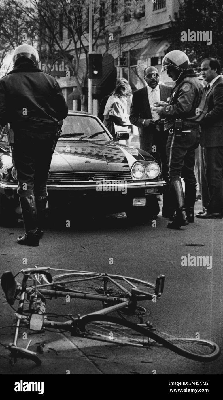 6 marzo 1985 - lo speaker dell'Assemblea Willie Brown ha investito un ciclista su L St. E l'ingresso al garage del Campidoglio intorno alle 9:00. Lo speaker dell'Assemblea Willie Brown, accanto all'auto con l'agente di polizia, offre la sua versione della collisione con un ciclista il ciclista, in condizioni discrete con una commozione cerebrale e le lacerazioni dovrebbero essere accolte per l'esecuzione di un semaforo rosso. Il ciclo è in primo piano. (Immagine di credito: © Frank Stork/Sacramento Bee/ZUMA Wire) Foto Stock