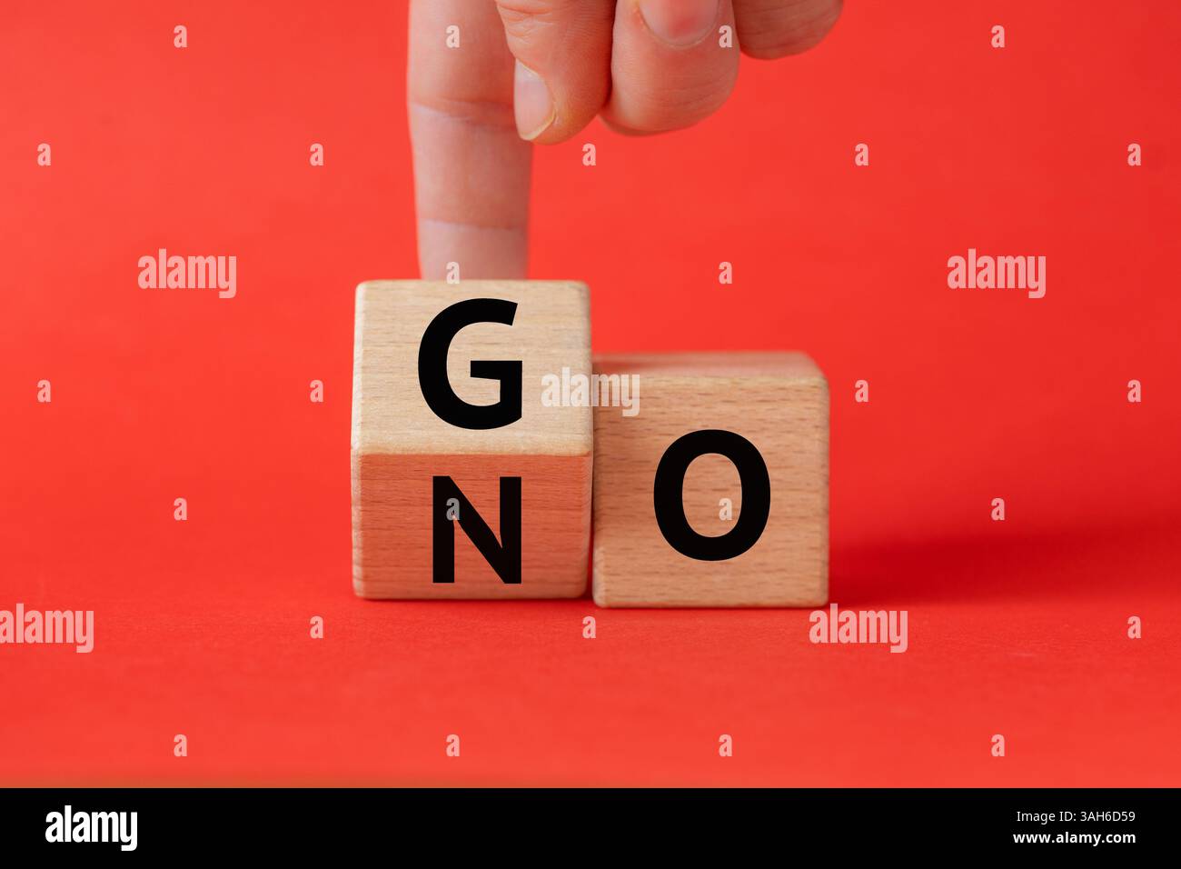Uomo d'affari che cambia la parola "NO to GO". Concetto di business. Bellissimo sfondo rosso. Copia spazio Foto Stock
