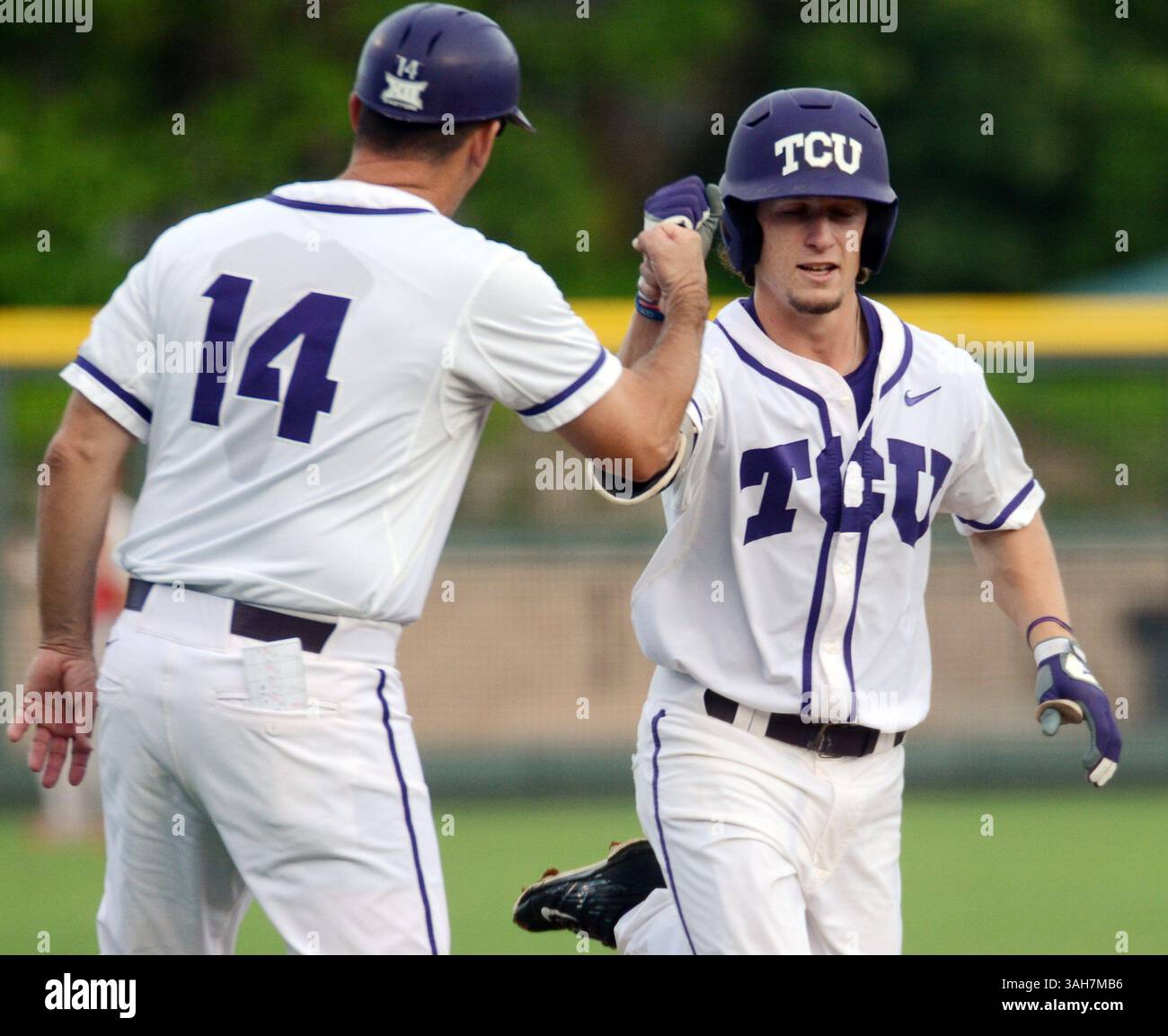 29 maggio 2015 - Fort Worth, Texas, USA - l'allenatore della terza base cristiana del Texas Bill Mosielllo, a sinistra, colpisce Cody Jones mentre fa jogging intorno alla terza base dopo aver colpito un fuoricampo solitario contro il Sacred Heart nel campionato NCAA Division i di baseball, Fort Worth Regional, al Lupton Stadium di Fort Worth, Texas, venerdì 29 maggio 2015. TCU ha vinto, 10-0. (Immagine di credito: © Bob Haynes/TNS/ZUMA Wire) Foto Stock