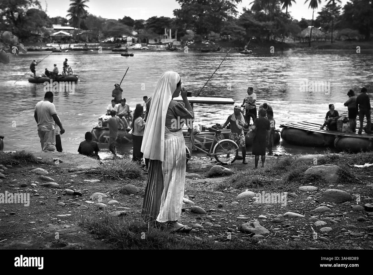 26 luglio 2014 - Tecum Uman, Guatemala - Una donna di un gruppo evangelico di donne in El Salvador guarda oltre il fiume Suchiate dal lato del Guatemala in cerca di una ''sorella'' del suo gruppo, sul lato messicano, mentre gli immigrati e il commercio attraversano il fiume Suchiate che è il confine tra Guatemala e Messico, a Tecum Uman, Guatemala mercoledì 30 luglio 2014. Ironicamente, gli immigrati avrebbero attraversato un ultimo fiume - il Rio grande sul confine messicano-texano - prima di entrare negli Stati Uniti. (Immagine di credito: © San Antonio Express-News/ZUMA Wire) Foto Stock